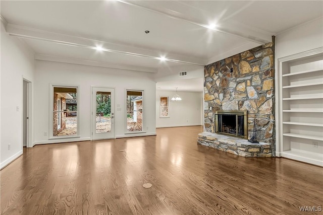 unfurnished living room featuring beam ceiling, a stone fireplace, and hardwood / wood-style floors