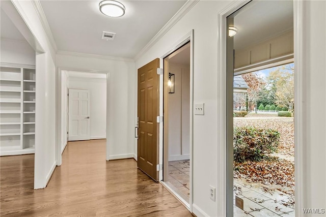 hall with light wood-type flooring and ornamental molding