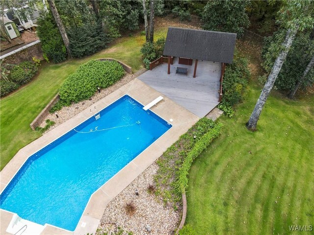 view of pool featuring a lawn, a diving board, and a deck