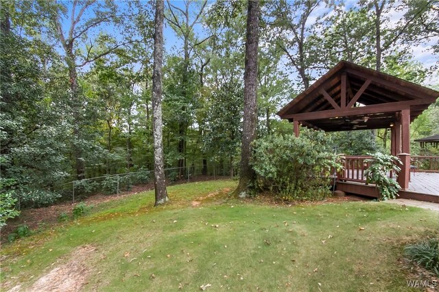 view of yard featuring ceiling fan and a wooden deck