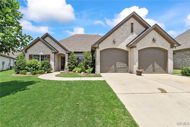 11441 Stella Way, Northport, AL 35475 - french country home featuring brick siding, an attached garage, a front yard, and driveway