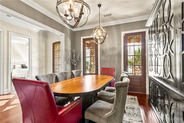 1006 Shady Tree Ln, Tuscaloosa, AL 35406 - dining room with crown molding, dark wood-style floors, visible vents, arched walkways, and an inviting chandelier