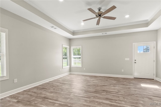 unfurnished room with hardwood / wood-style flooring, a raised ceiling, ceiling fan, and ornamental molding