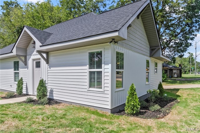 view of side of home with a yard