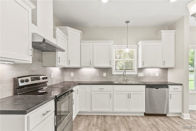 kitchen featuring stainless steel appliances, sink, decorative light fixtures, light hardwood / wood-style floors, and white cabinetry