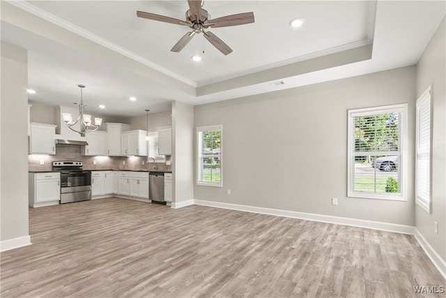 kitchen with light hardwood / wood-style flooring, crown molding, decorative light fixtures, white cabinets, and appliances with stainless steel finishes