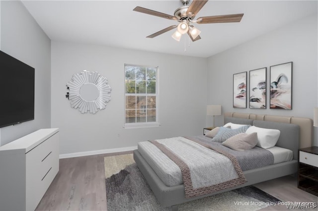 bedroom featuring ceiling fan, baseboards, and wood finished floors