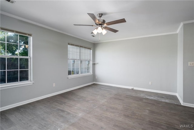 empty room featuring crown molding, wood finished floors, and baseboards