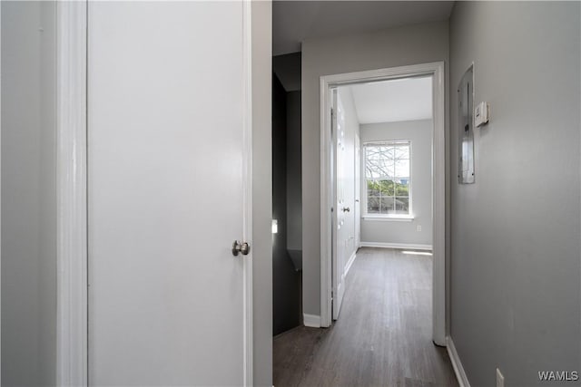hallway with baseboards and wood finished floors