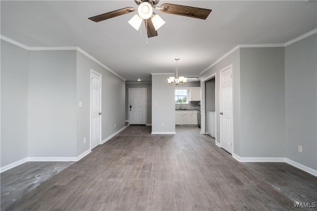 unfurnished living room featuring dark wood-type flooring, ceiling fan with notable chandelier, baseboards, and ornamental molding