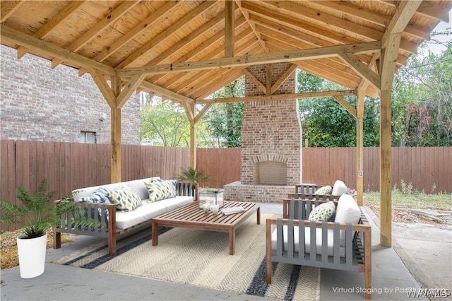 view of patio / terrace featuring a fenced backyard, an outdoor living space with a fireplace, and a gazebo