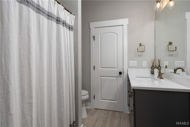 bathroom with hardwood / wood-style floors, toilet, and vanity