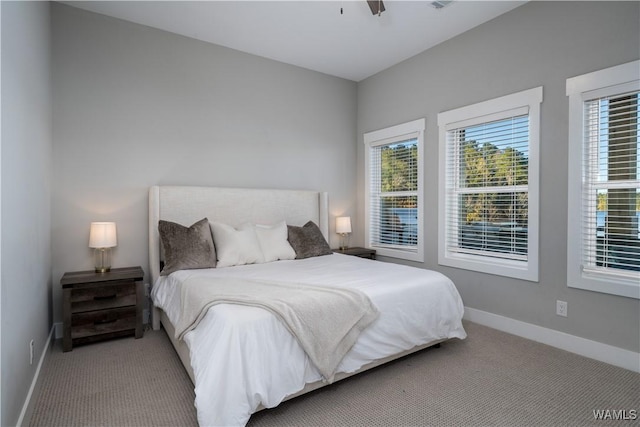 bedroom featuring multiple windows, ceiling fan, and light colored carpet