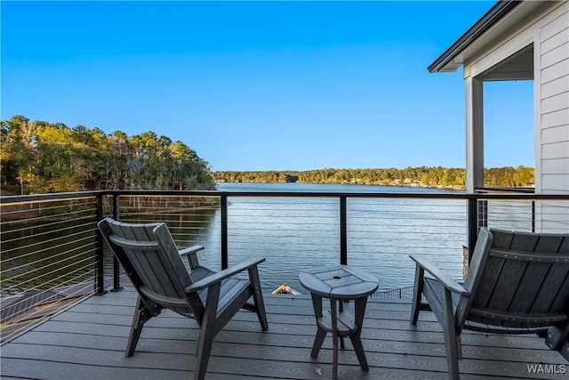 view of dock with a balcony and a water view