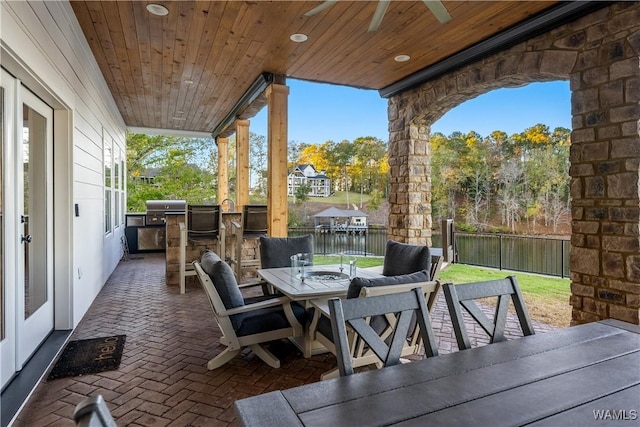 view of patio / terrace with ceiling fan, exterior bar, and a water view