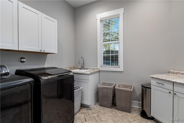 laundry room featuring washer and dryer, sink, and cabinets