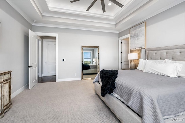 bedroom with carpet floors, ceiling fan, crown molding, and a tray ceiling