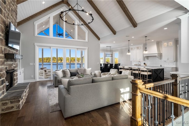 living room with a fireplace, high vaulted ceiling, dark wood-type flooring, and beamed ceiling