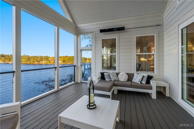 sunroom with vaulted ceiling and a water view