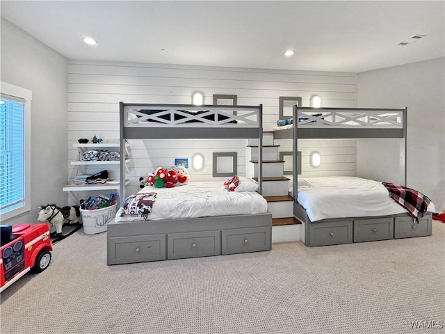 carpeted bedroom with wood walls