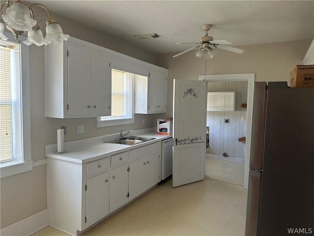 kitchen with dishwasher, stainless steel fridge, a textured ceiling, and white cabinetry