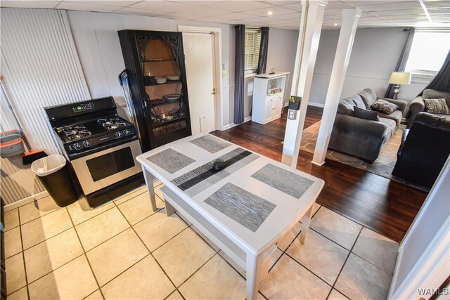 3207 33rd St, Northport, AL 35476 - kitchen featuring tile patterned floors, decorative columns, stainless steel range with gas stovetop, and a drop ceiling