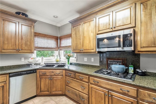 2940 Lake Crest Dr, Tuscaloosa, AL 35406 - kitchen featuring appliances with stainless steel finishes, light tile patterned flooring, dark countertops, brown cabinetry, and crown molding