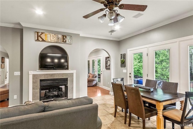 2940 Lake Crest Dr, Tuscaloosa, AL 35406 - dining area with arched walkways, crown molding, ceiling fan, light tile patterned flooring, and a fireplace