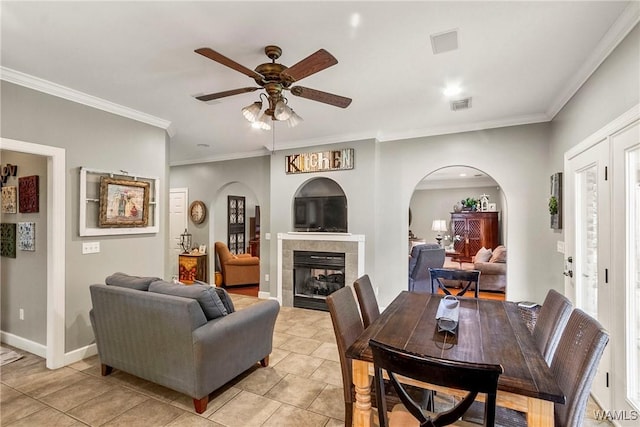 2940 Lake Crest Dr, Tuscaloosa, AL 35406 - living room with arched walkways, ceiling fan, ornamental molding, light tile patterned floors, and a tiled fireplace