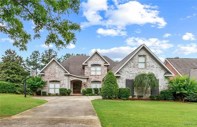 2940 Lake Crest Dr, Tuscaloosa, AL 35406 - french country inspired facade with brick siding, a front lawn, and driveway