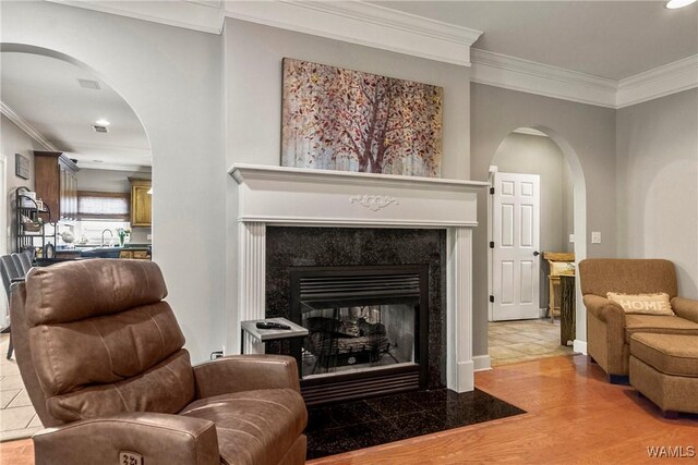 2940 Lake Crest Dr, Tuscaloosa, AL 35406 - living room featuring arched walkways, crown molding, a high end fireplace, recessed lighting, and wood finished floors