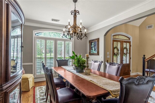 2940 Lake Crest Dr, Tuscaloosa, AL 35406 - dining area with arched walkways, a chandelier, wood finished floors, and ornamental molding