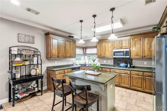 2940 Lake Crest Dr, Tuscaloosa, AL 35406 - kitchen featuring stainless steel appliances, brown cabinets, light tile patterned flooring, crown molding, and a center island