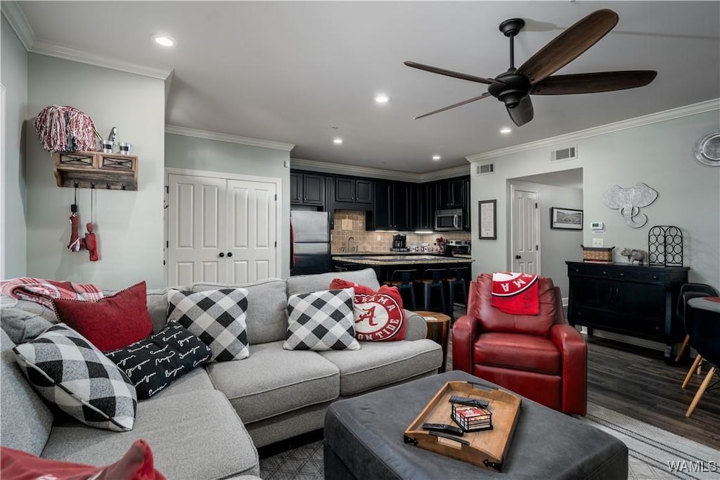 living room featuring crown molding, dark wood-type flooring, and ceiling fan