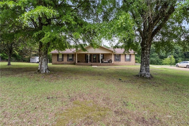 ranch-style house with covered porch, brick siding, and a front yard