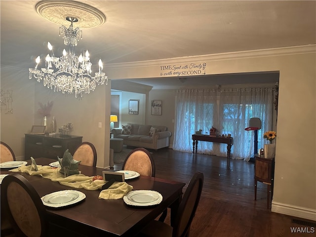 dining room with dark hardwood / wood-style floors, ornamental molding, and a notable chandelier