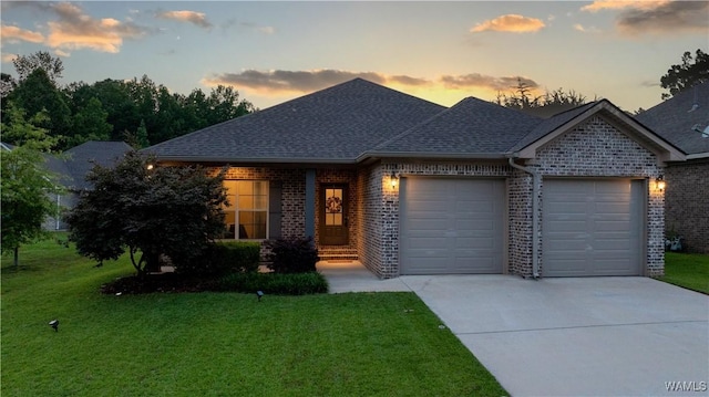 13982 Knoll Pointe Dr, Northport, AL 35475 - view of front of house featuring an attached garage, driveway, brick siding, and a lawn