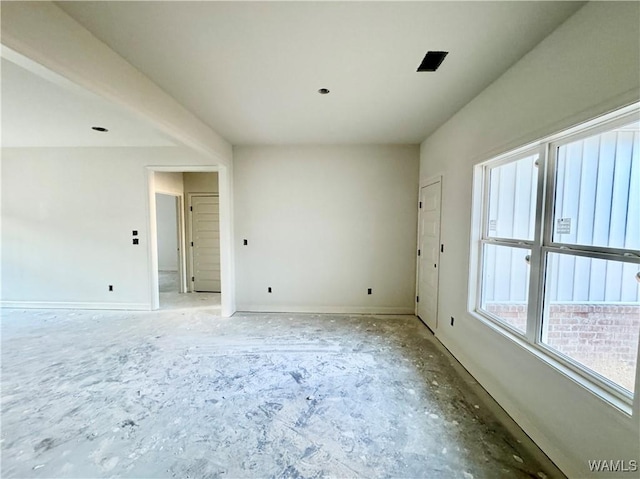 unfurnished room with baseboards