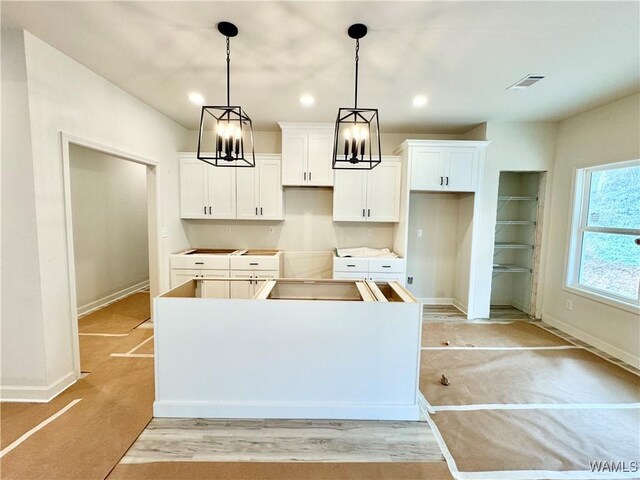 kitchen featuring white cabinetry, an island with sink, sink, and dark stone countertops