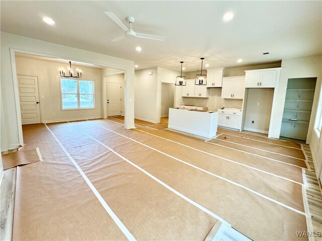 unfurnished living room with sink, ceiling fan, and light hardwood / wood-style flooring