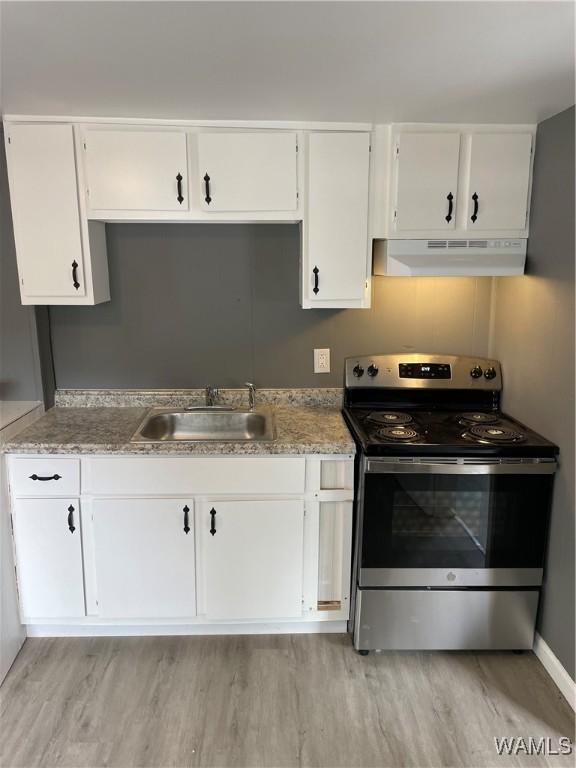 kitchen with white cabinets, light wood-type flooring, sink, and electric stove