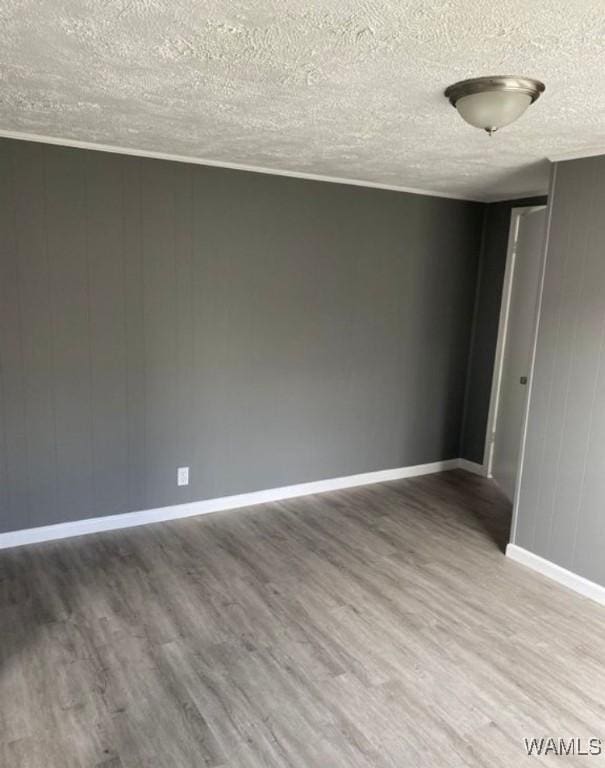 unfurnished room featuring a textured ceiling and hardwood / wood-style flooring