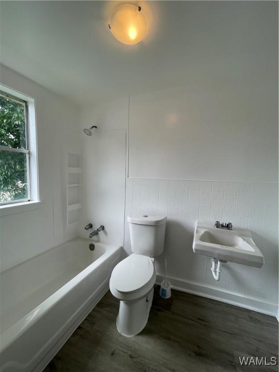 full bathroom featuring hardwood / wood-style floors, shower / bath combination, toilet, and sink