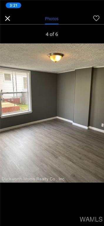 unfurnished room with wood-type flooring and a textured ceiling