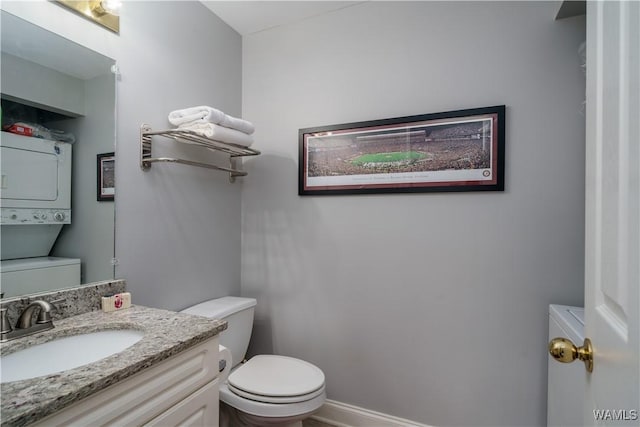 bathroom with vanity, toilet, and stacked washer and dryer