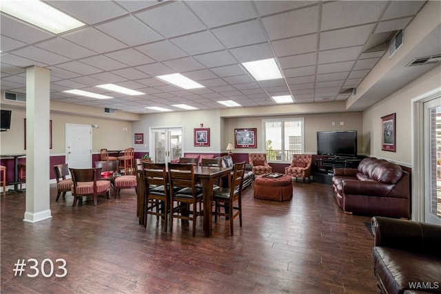 dining area featuring a paneled ceiling and dark hardwood / wood-style flooring