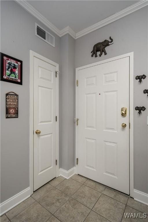 tiled entrance foyer featuring crown molding