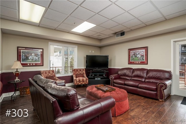 living room featuring a paneled ceiling and dark hardwood / wood-style floors