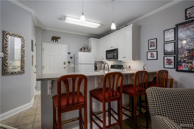 kitchen with a breakfast bar area, white cabinets, kitchen peninsula, and white fridge