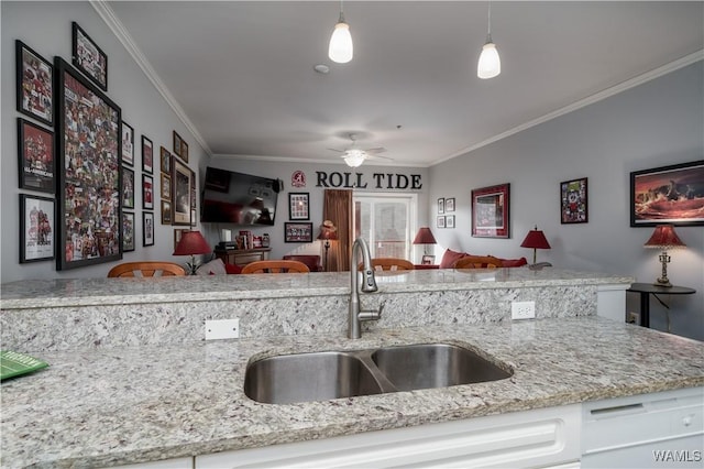 kitchen featuring light stone counters, sink, white cabinets, and hanging light fixtures